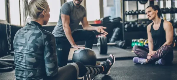 young women talking to a personal training coach