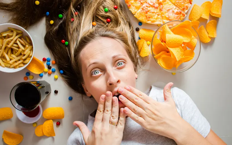 shocked woman surrounded by unhealthy foods