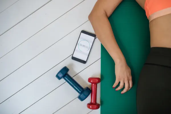 woman with dumbbells and a smartphone