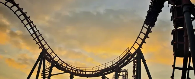 Silhouette of a rollercoaster at sunset symbolising emotional ups and downs in fitness journeys – blog by 5th Element Wellness Fitzroy