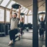 Group of people lifting weights in a gym, guided by coaches — illustrating effective training using Reps in Reserve (RIR) method