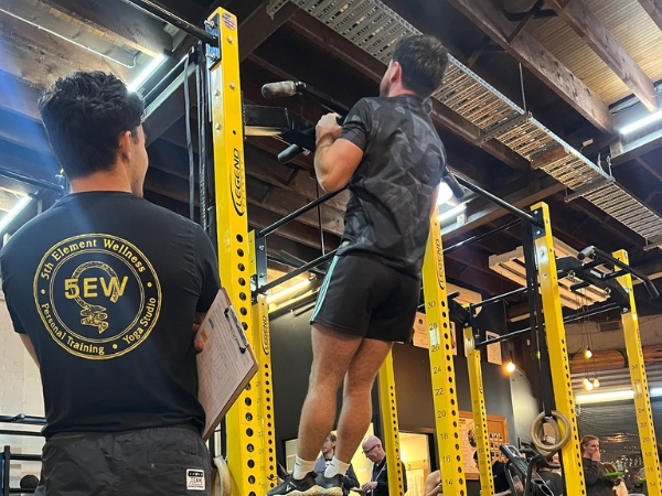 Returning to exercise after a long break at 5th Element Wellness in Fitzroy North, showing a coach supervising assisted pull-ups to build strength and confidence.