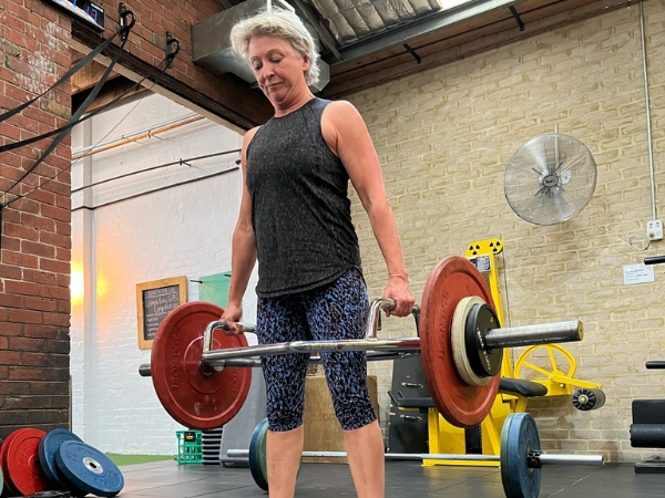 PT For Over 40_ Data That Helps You Age Stronger Personal training for adults over 40 at 5th Element Wellness in Fitzroy North, showing a coach assisting a client in a supported elbow plank during a strength and stability assessment.