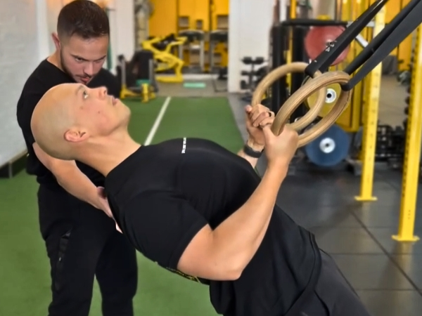 Personal trainer for back pain in Fitzroy North supervising a sled push to build lower-body strength, core stability, and confidence in movement.