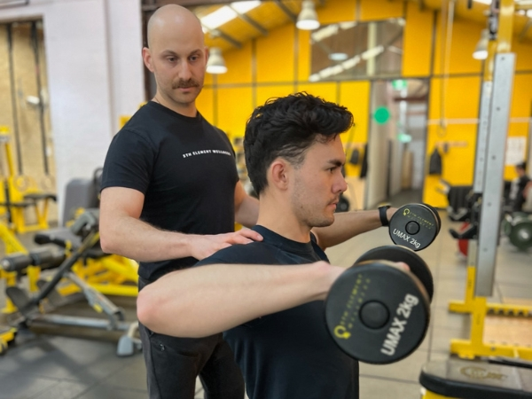 PT For Returning to Exercise_ You’re Not Starting From Zero (3) PT for busy adults at 5th Element Wellness in Fitzroy North, showing a personal trainer supervising an elbow plank to build core strength, posture, and resilience.