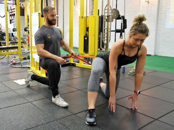 Personal Training Movement Assessment – 5th Element Wellness Personal trainer guiding a client through a movement assessment and mobility exercise at 5th Element Wellness Fitzroy North