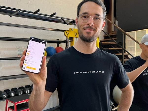 Personal Training Program Support at 5th Element Wellness Fitzroy North Personal trainer at 5th Element Wellness Fitzroy North showing a personalised training program app during a personal training session
